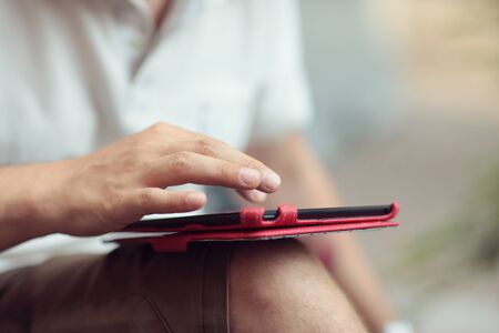 Young man using a digital tablet, hands close up. Shallow deep of fieldの写真素材