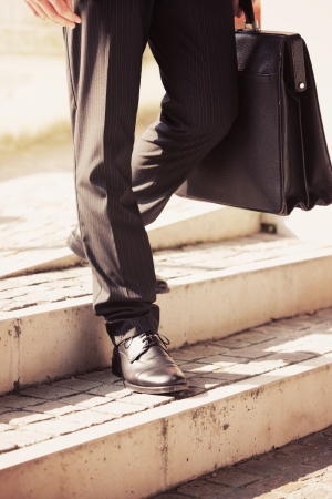 Businessman walks with his briefcase down a staircaseの写真素材