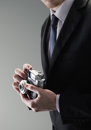 An elegant businessman holding a vintage cameraの写真素材