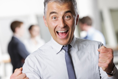 Happy mature business man celebrating his successの写真素材