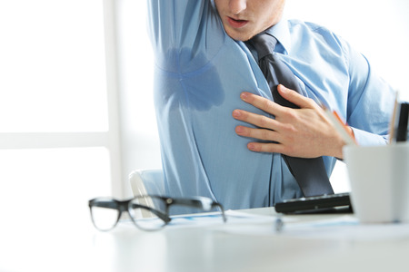 A young business man notices his sweat
