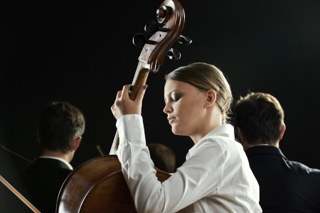 Young beautiful woman playing cello in orchestraの写真素材