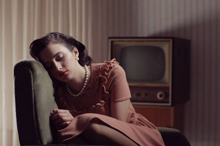 Young woman sleeping on armchair, 1950 styled 