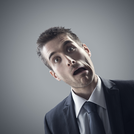 Portrait of stressed business man on grey の写真素材
