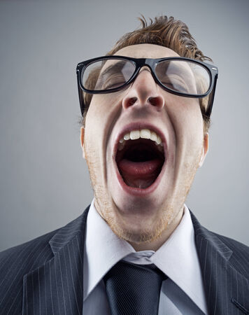 Portrait of tired Nerdy business man yawningの写真素材