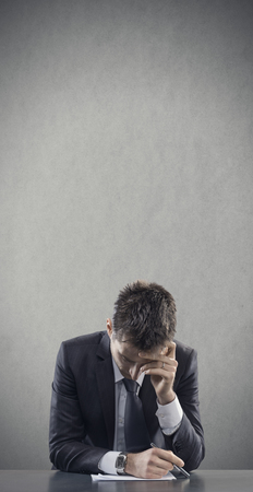 Depressed and tired office worker at desk. Copy spaceの写真素材