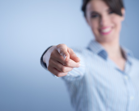 Beautiful young woman smiling and pointing at camera.の写真素材