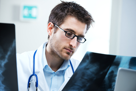 Professional radiologist examining an X-ray image of human spine.の写真素材