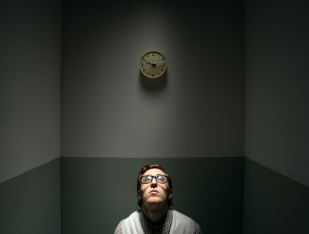 Lonely nerd guy feeling depressed in his small room.の写真素材