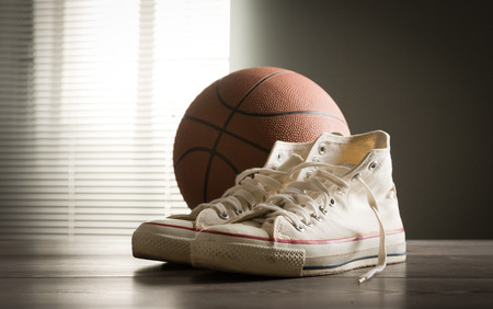 White sneakers with basketball on a wooden table.の写真素材