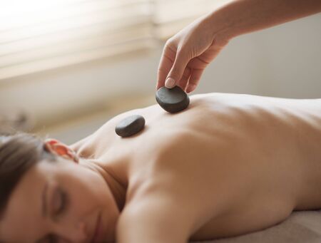 Young woman receiving a lastone spa treatment and relaxing.の写真素材