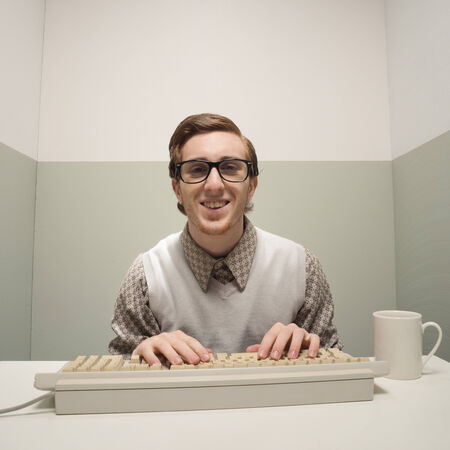 Vintage nerd guy working on old computer in a small room.