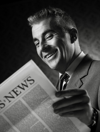 Handsome businessman reading news against vintage wallpaper background.の写真素材