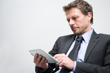 Attractive businessman working with tablet and touching digital display.
