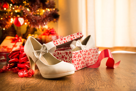 White female elegant shoes in a gift box with christmas tree and presents on background.の写真素材