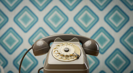 Vintage gray telephone on diamond light blue retro wallpaper 1960s style.の写真素材