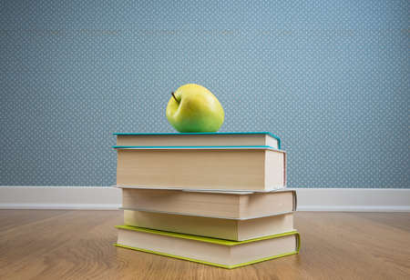 Pile of books with yellow apple on floor, back to school concept.の写真素材