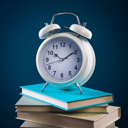 Back to school concept with pile of books and vintage alarm clock.の写真素材