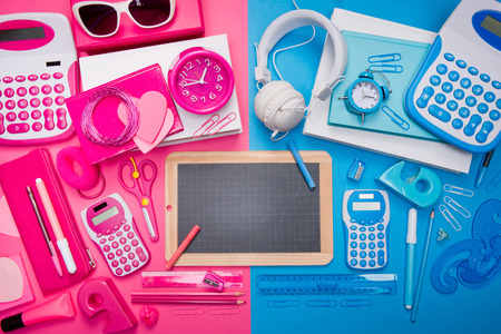 Boy and girl desktop with pink and blue stationery and blackboard at center.の写真素材