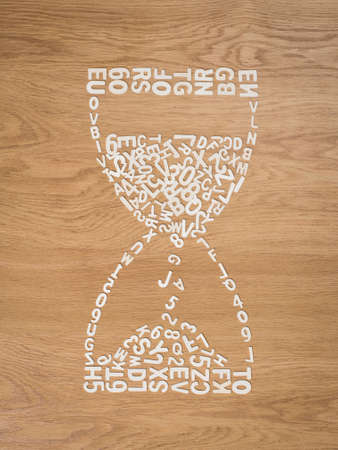 Creative houglass composed of plastic white letters and numbers on the floor.