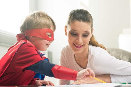 Mother and son drawing and enjoying time together in the living room.の写真素材