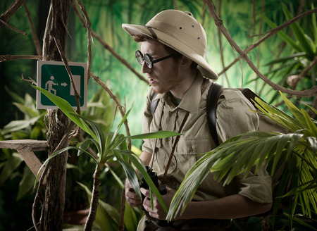 Young colonial style explorer in the jungle finding an exit sign.の写真素材