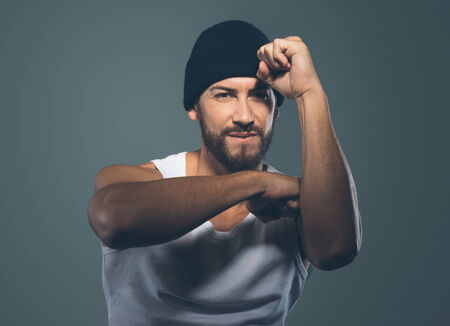 Cool stylish rapper gesturing and smiling at camera