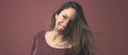 Beautiful young woman posing with messy hair smiling at camera