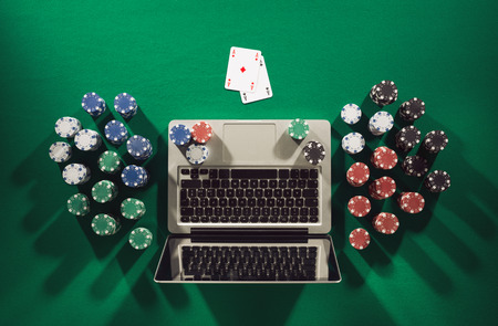 Online poker game app concept with ace cards and stacks of chips on green table, top view