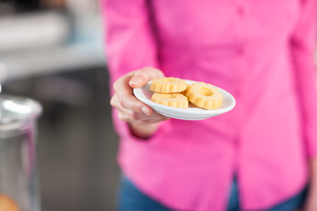 Waitress serving a dish with butter cookies hands close upの写真素材