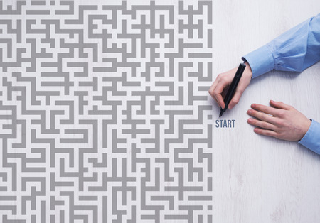 Businessman entering a maze and holding a marker business strategy and challenge conceptの写真素材