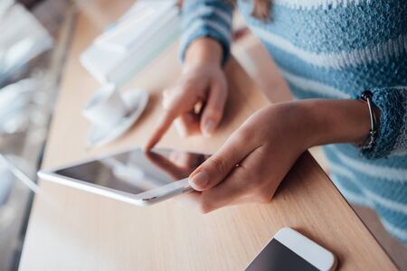 Woman using a touch screen tablet hands close up