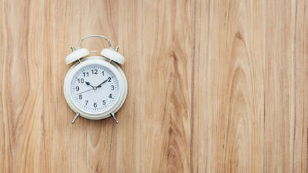 Vintage alarm clock on a wooden table, urgency and deadlines conceptの写真素材