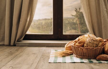 Fresh tasty bread in a basket in front of a window, traditional food and healthy lifestyle conceptの写真素材
