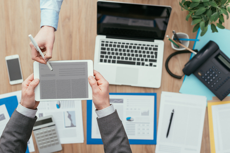 Business people meeting in the office and using a digital tablet; digital signature, apps and online forms conceptの写真素材