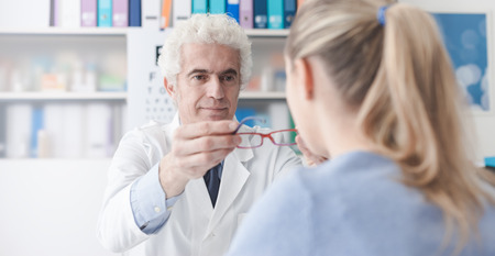 Ophthalmologist giving glasses to the patient, eye care conceptの写真素材