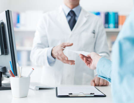 Customer giving a medical prescription to the pharmacist, treatment and healthcare conceptの写真素材