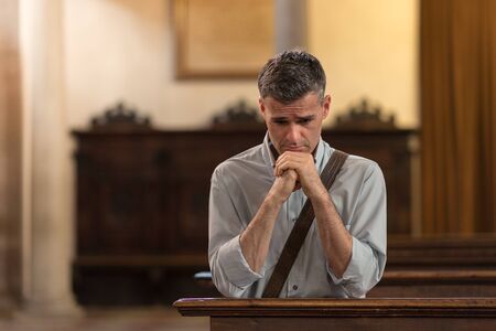 Man kneeling and praying in the Churchの写真素材