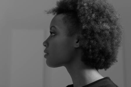 Beautiful young african american woman posing, she is looking away, profile viewの写真素材