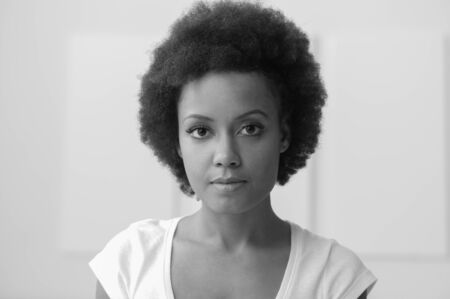 Confident young african american woman posing and looking at cameraの写真素材