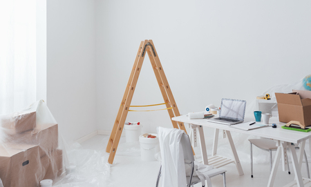 Home makeover, renovation and decoration: home interior with a ladder, boxes, paint buckets and...
