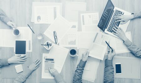 Business team working at office desk with paperwork, a laptop and a digital tablet, teamwork and finance conceptの写真素材