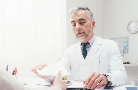 Doctor giving a prescription to his patient, healthcare and hospitals conceptの写真素材
