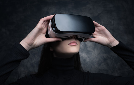 Young beautiful woman wearing a VR headset and experiencing virtual reality