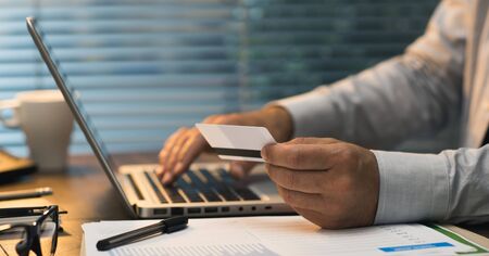 Businessman doing online banking, he is making e-payments with a credit card and his laptop, online...