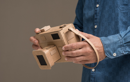 Photographer holding an handmade eco-friendly cardboard camera, crafts and creativity conceptの写真素材