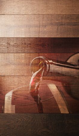 Wine pouring into a glass on a rustic wooden surface, wine culture backgroundの写真素材