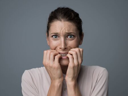 Terrified young woman looking at camera, she is feeling scared and shaking