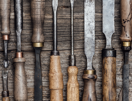 Set of used professional carving and woodworking tools on the workbench close up: carpentry,...
