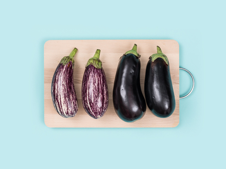 Fresh eggplants on a wooden chopping board, food preparation and healthy eating conceptの写真素材